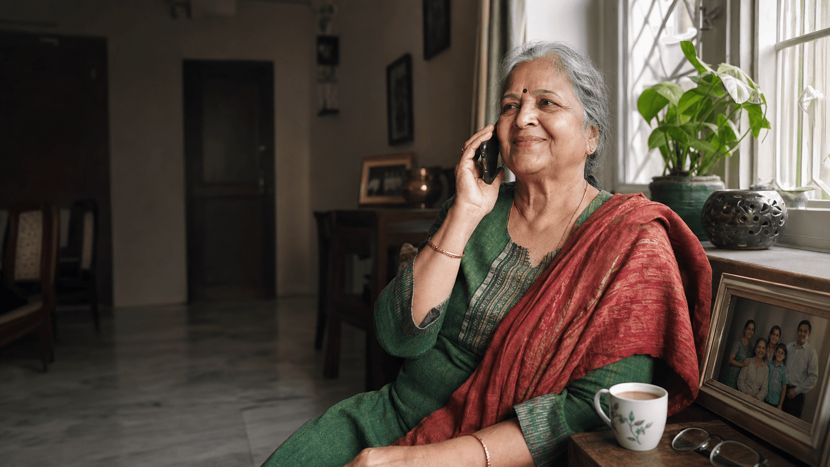 An Indian grandmother speaking warmly on the phone at home